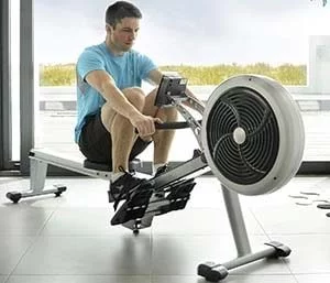 Man working out with JTX Freedom Air Rowing machine