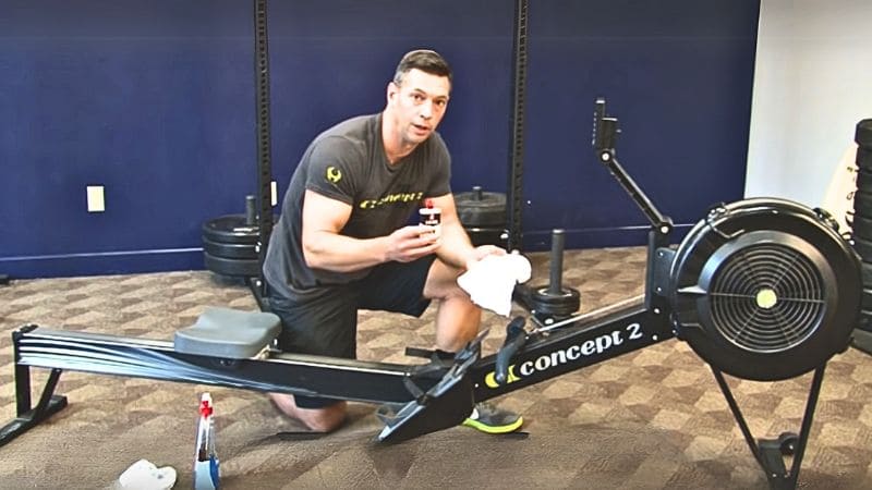 Man doing a regular maintenance of a Rowing Machine